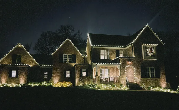 Custom Christmas lights installed along the roofline and landscaping of a Williamson County home