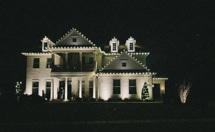 Custom Christmas lights installed along the roofline and landscaping of a Williamson County home