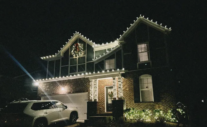 Custom Christmas lights installed along the roofline and landscaping of a Williamson County home