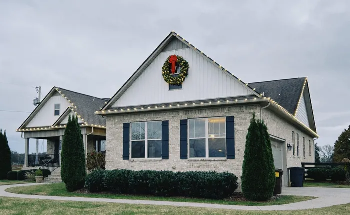 Holiday lighting along a home's porch, columns, and landscaping